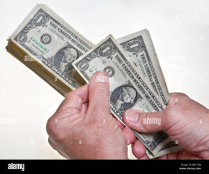 billetes de dolares apilados y mano contando