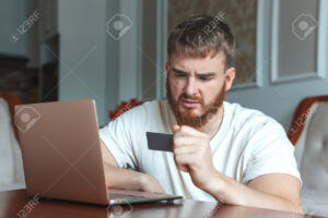 persona confundida usando computadora portatil bancaria