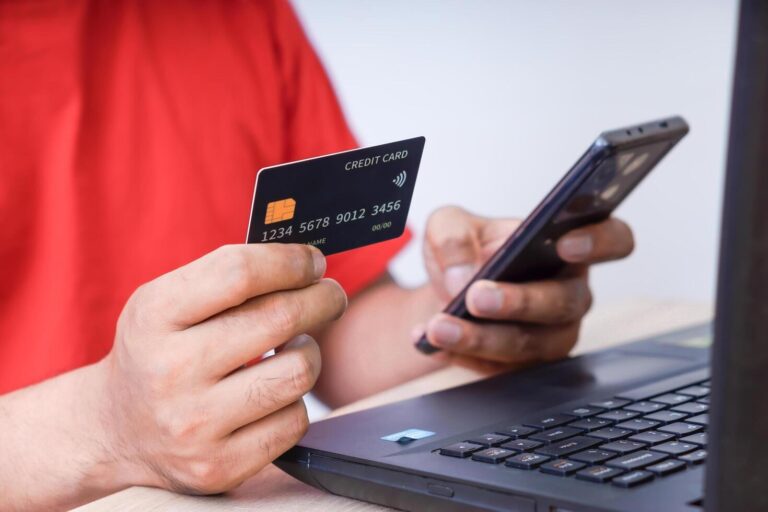 persona pagando con laptop y smartphone